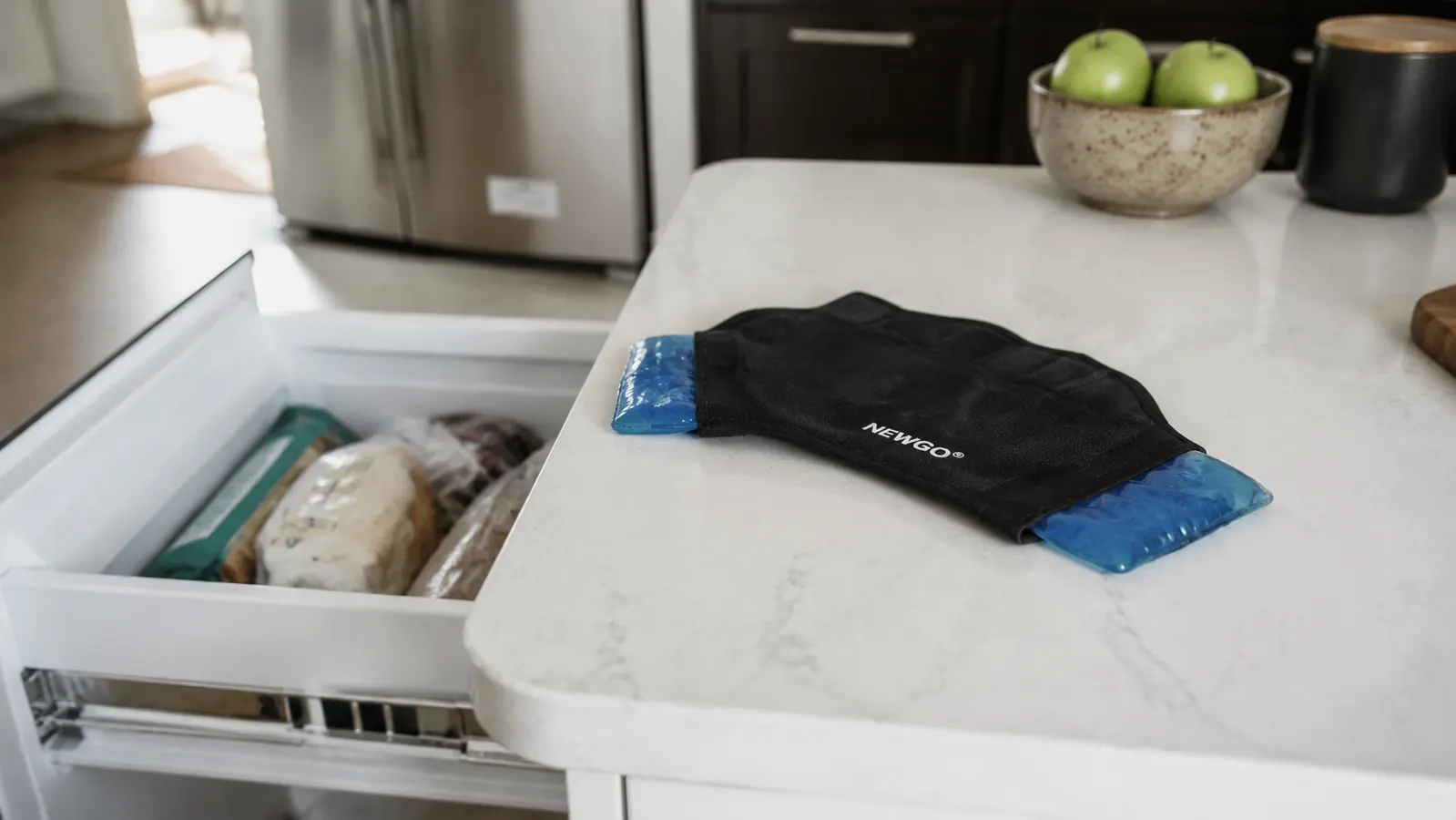 Ice pack wrap resting on a kitchen counter next to a freezer door, ready for use