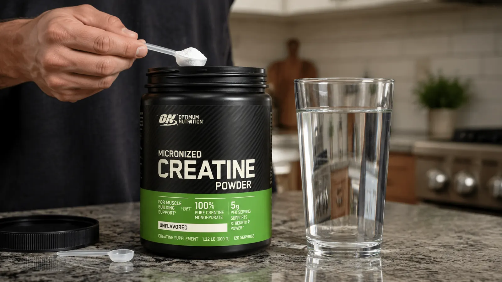 Optimum Nutrition Micronized Creatine Monohydrate container next to a measuring teaspoon and a glass of water