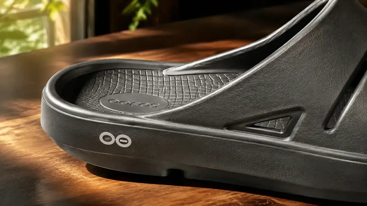 A close-up of the thick foam footbed of an OOFOS OOahh slide highlighting arch support and cushioning depth