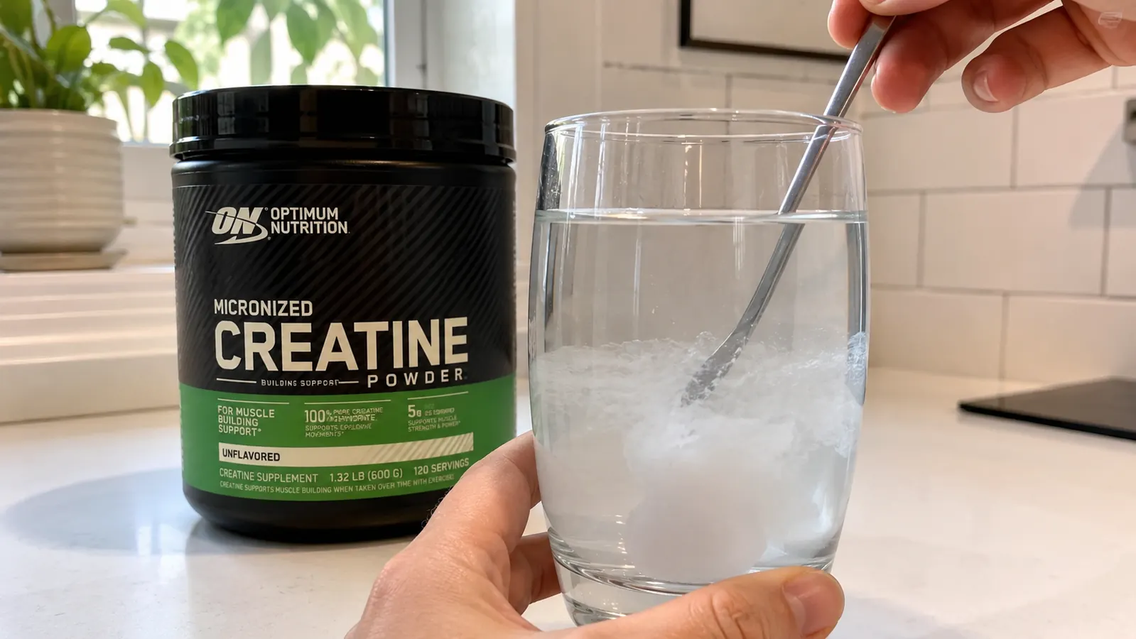 Close-up of a partially dissolved white creatine powder in a glass of water, showing slight cloudiness before full mixing, realistic kitchen setting