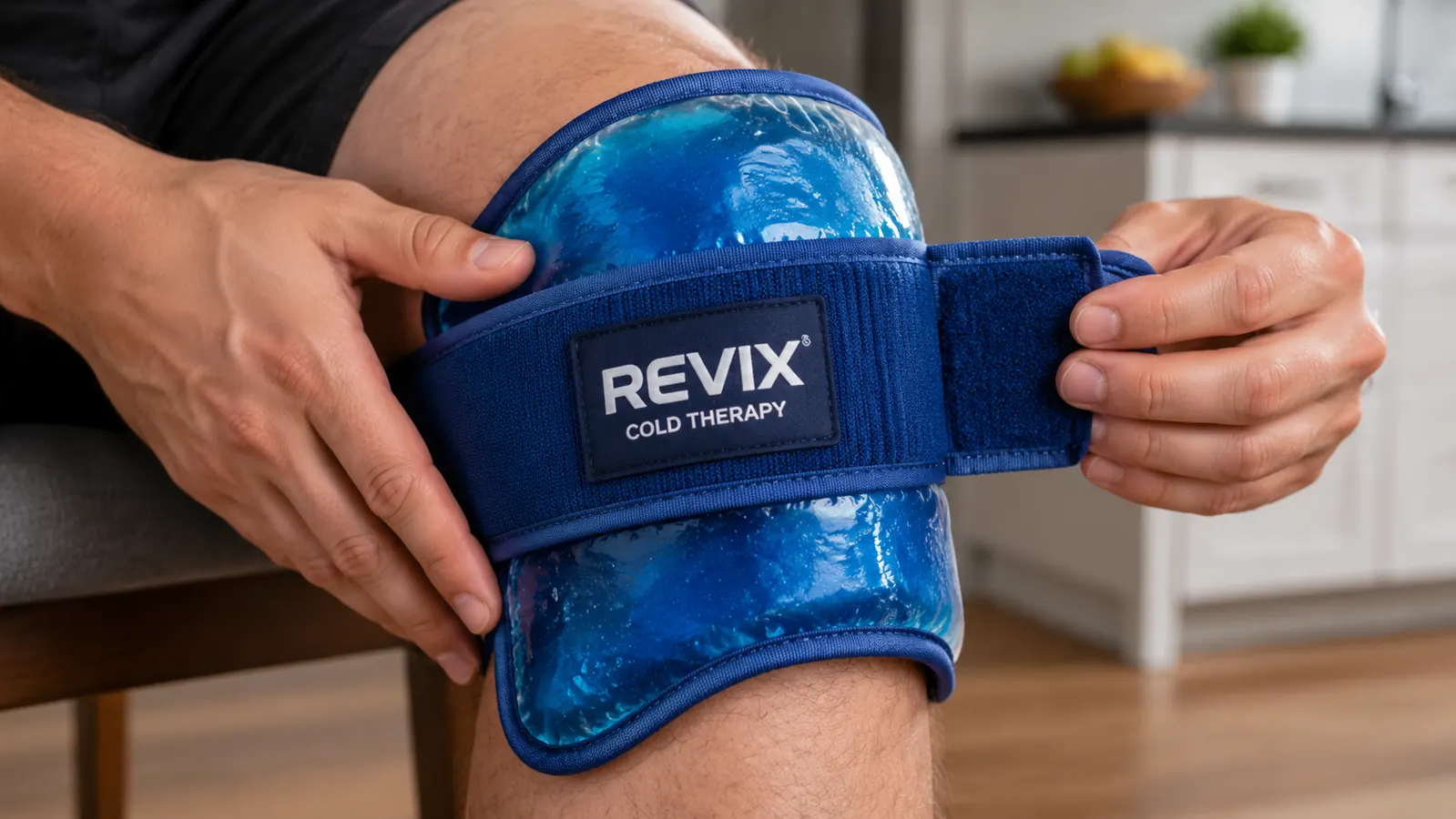 Close-up of hands pressing a blue gel ice wrap against a knee and fastening the velcro strap
